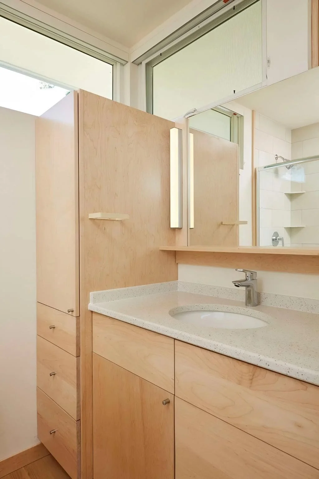 Custom bathroom vanity with wood cabinetry, integrated storage, and modern fixtures