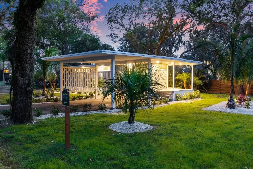 Exterior view of the N1 Tiny Home on Lot 26 at Escape Tampa Bay surrounded by lush landscaping