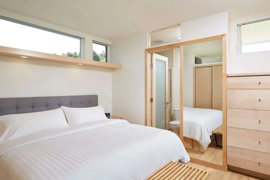 Bright king bedroom with built-in storage, large windows, and modern finishes