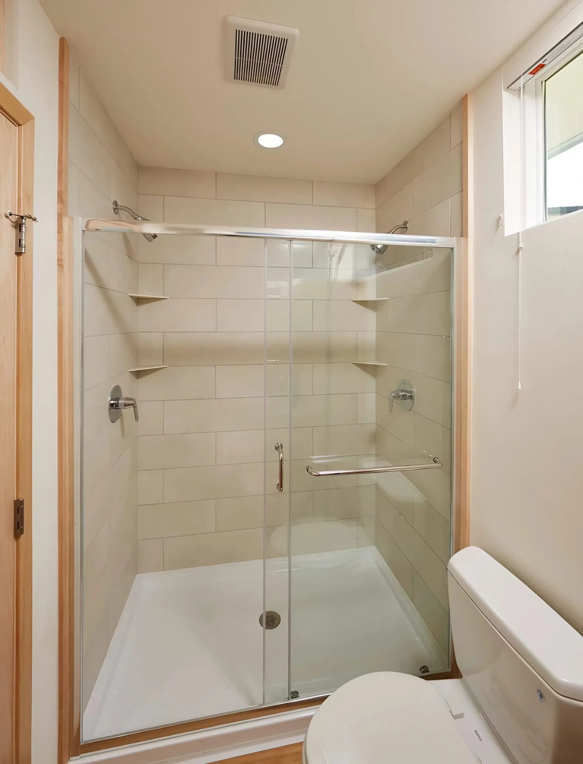 Spacious glass-enclosed tile shower in the ensuite bathroom of the N1 Tiny Home